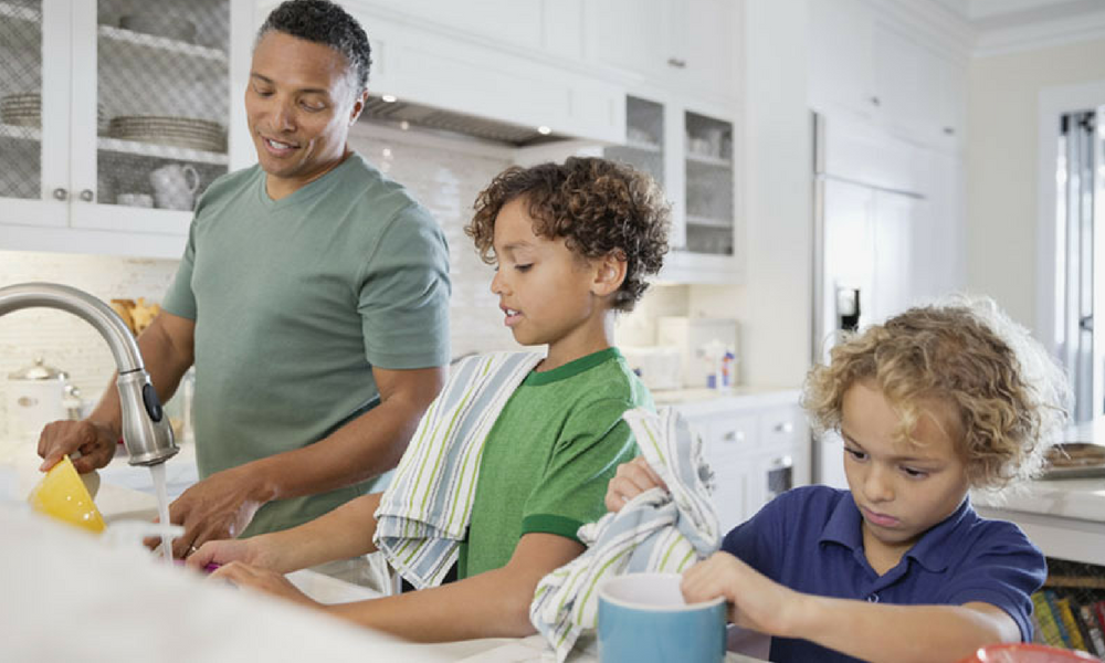 Niños realizando las tareas domésticas con la supervisión de su padre