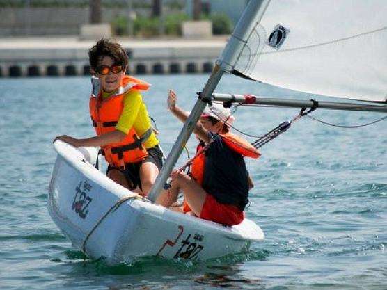 Niños practicando vela en Roses, en verano. 